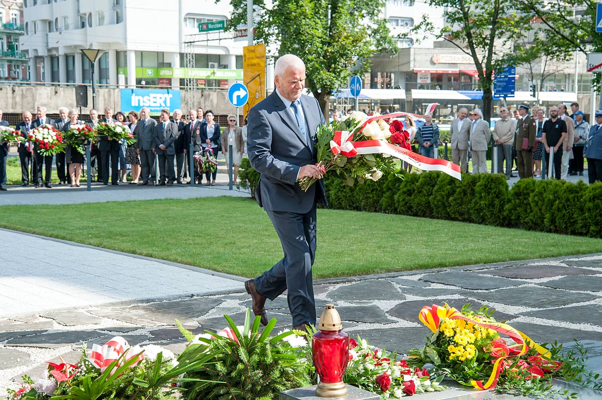 rektor składa kwiaty pod pomnikiem