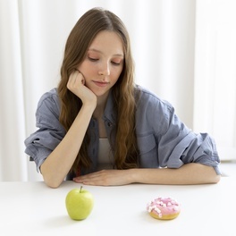 woman-looking-doughnut-apple.jpg